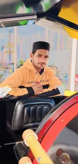 Man in casual attire on a colorful amusement ride.