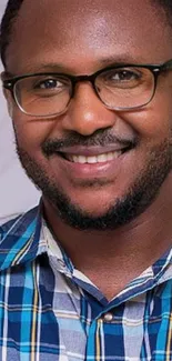 Portrait of a smiling person in a blue plaid shirt.