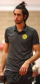 Person in grey sports shirt standing indoors.