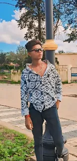 Casual fashion style with sunglasses and patterned shirt outdoors.