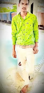 Man in green shirt posing in urban setting with relaxed style.