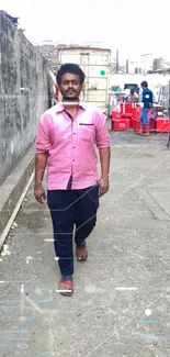 Man walking on an urban street in a casual setting against a gritty backdrop.