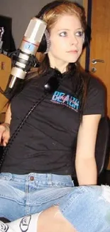 Girl in studio wearing black tee and denim.