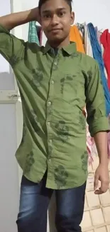 Man wearing a green shirt with a relaxed pose.