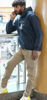 Man in casual attire leaning on rail.