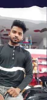 Man in a black shirt posing indoors, casual style.