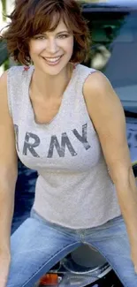 Person in casual outfit sitting on car's hood, smiling.