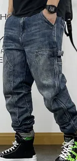 Person wearing denim joggers and sneakers in urban style.