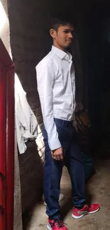 Man in white shirt and red shoes in an urban setting.