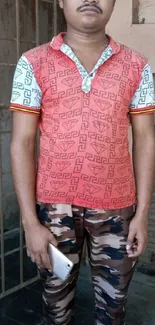 Man in geometric shirt with camo pants, orange dominant.