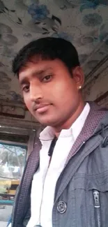 Portrait of a young man with a casual, urban backdrop.