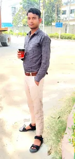 Casual man with cup in urban setting, beige and gray tones.