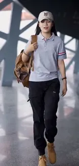 Person in casual grey polo and black pants walking.