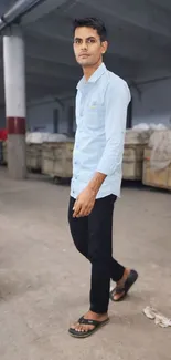 Casual style in a warehouse setting, showcasing a light blue shirt.