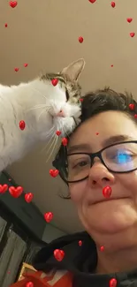 Cat with person surrounded by red hearts in a cozy setting.