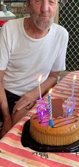 Man celebrating birthday with cake and candles.