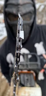 Masked person holding a chainsaw in a snowy landscape.