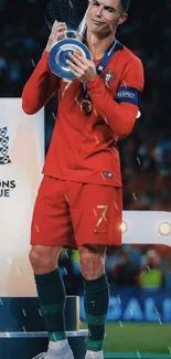 Soccer player celebrating with trophy.