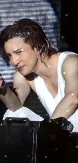 Charismatic performer in a white outfit at a concert.