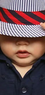 Adorable baby with striped hat and navy outfit.