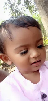 Adorable baby in pink in a natural outdoor setting.