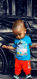 Baby stands confidently in front of a luxury black car wearing a colorful outfit.