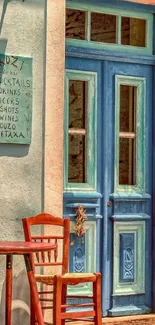 Vintage blue door with rustic chairs in charming cafe setting.