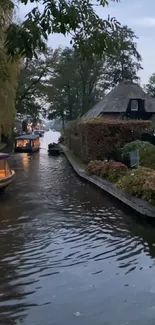 Peaceful canal scene with boats and cottages at dusk.