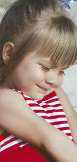 Young girl with striped top and blue bow at the beach.