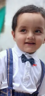 Smiling young boy in bow tie and suspenders.