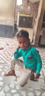 Young boy kneeling on tiled floor with a green shirt.