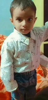 Adorable child in a stylish shirt and jeans, posing indoors.