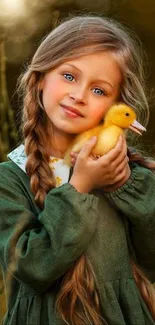 Charming child holding a duckling in nature scene.