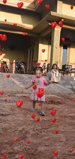 Child playing with hearts in front of a warm home.