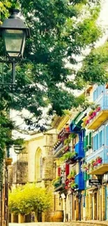 Cobblestone street with colorful buildings and lush greenery.