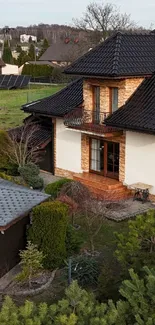 A charming countryside cottage with a dark slate gray roof surrounded by greenery.