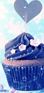 Blue cupcake with heart topper and flowers.