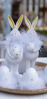 Cute Easter bunnies with white feathers and golden accents on a plate.