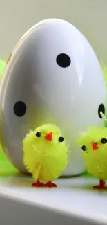 Yellow chicks and a dotted Easter egg on a light background.