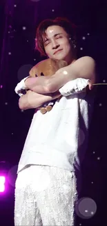 Charming performer on stage with plush bear, vivid purple lighting.