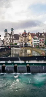 Picturesque riverfront European town wallpaper with historical architecture.