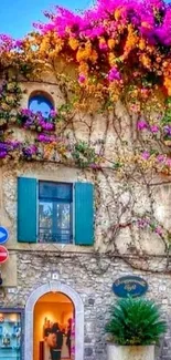 Rustic house with vibrant purple flowers cascading over the stone walls.