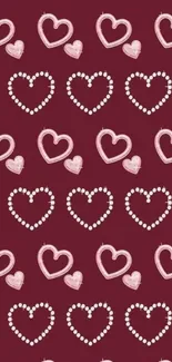 Charming phone wallpaper with pink and white heart patterns on a burgundy background.