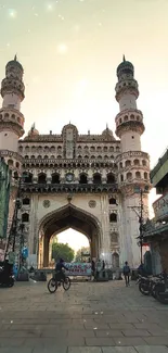 Iconic historical monument at sunset with vibrant urban backdrop.