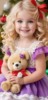 Smiling blonde child in purple dress with teddy bear and Christmas decor.