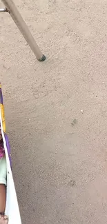 Infant peacefully sleeping in an outdoor hammock on sandy ground.