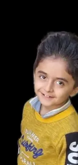 Smiling child in yellow sweater on black background.