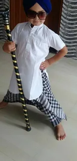 A stylish child in traditional clothing with a cane, striking a pose.