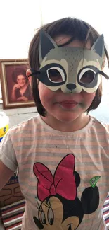 Child wearing a fox mask with colorful background.