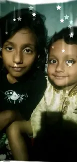 Two kids smiling with starry effects on a phone wallpaper.